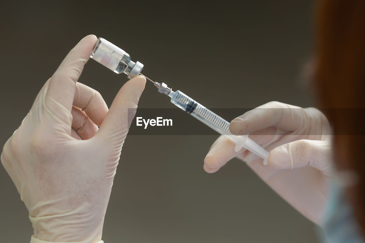 cropped hand of doctor holding thermometer