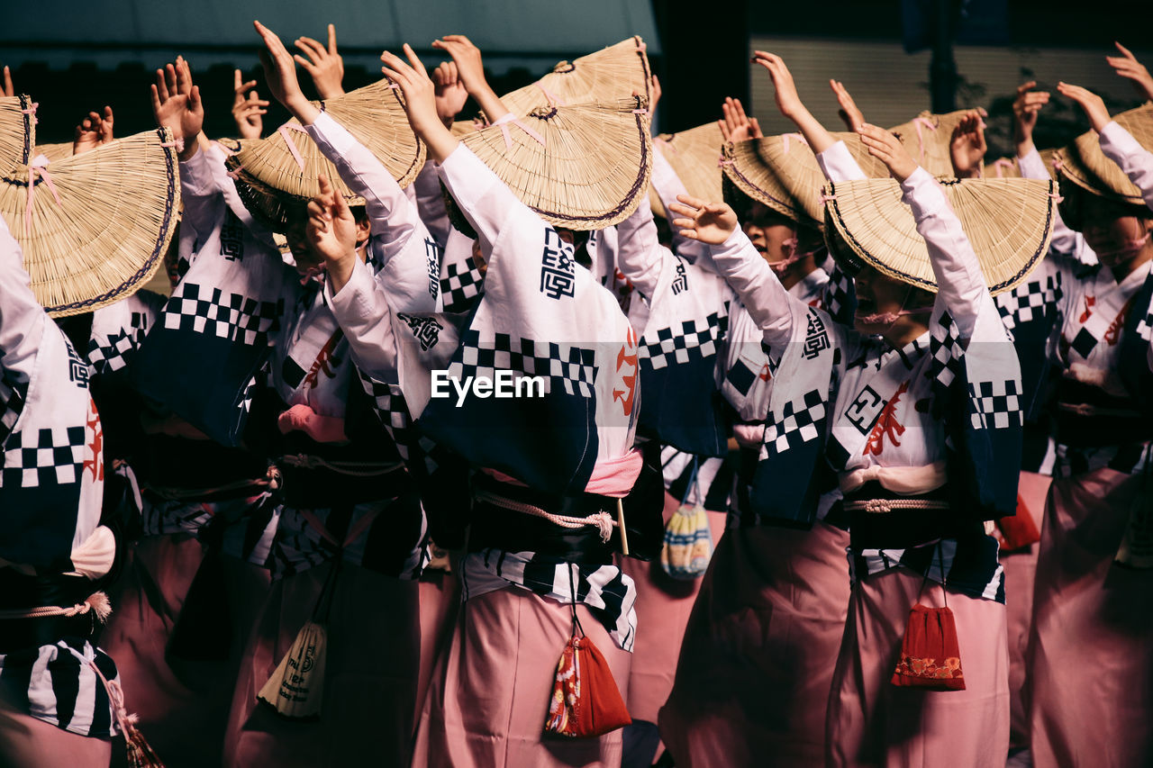 Women dancing with arms raised during awa dance festival
