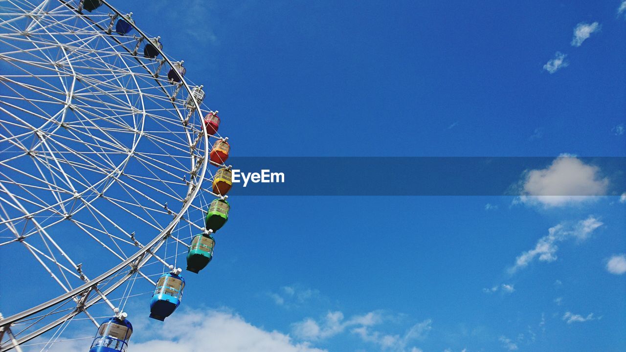 Low angle view of ferris wheel against blue sky