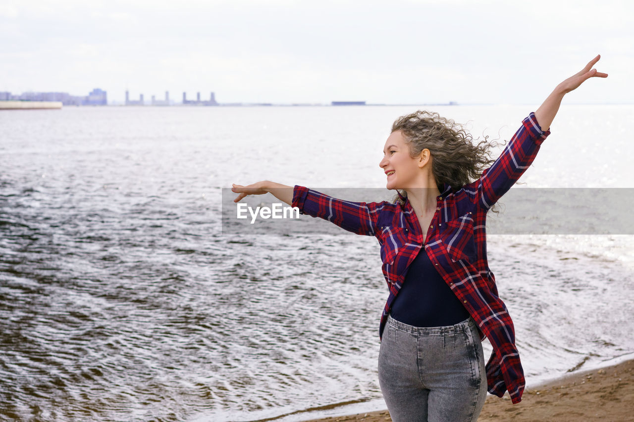 Full length of man standing at beach against sky