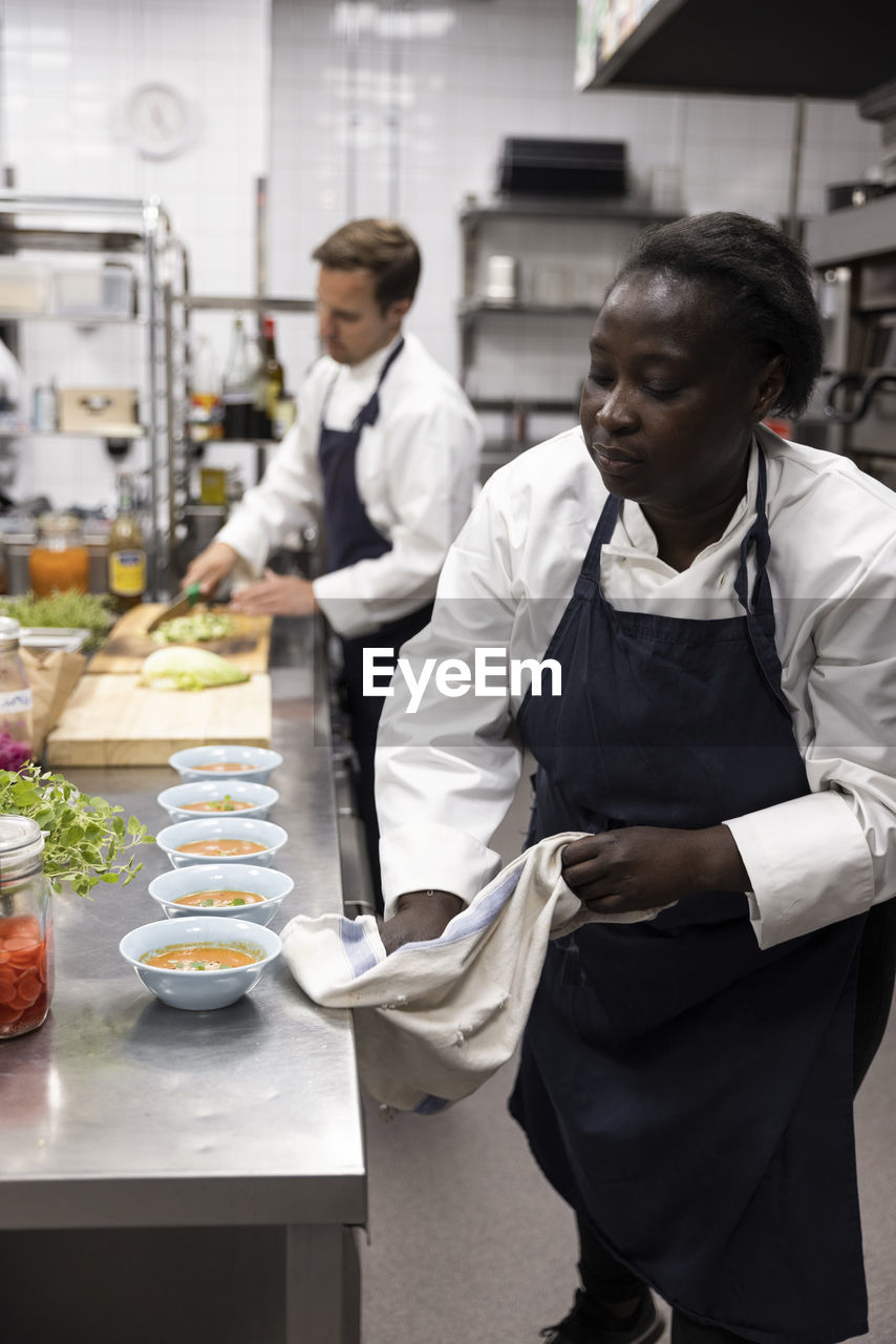 Chef cleaning kitchen counter while working in commercial kitchen