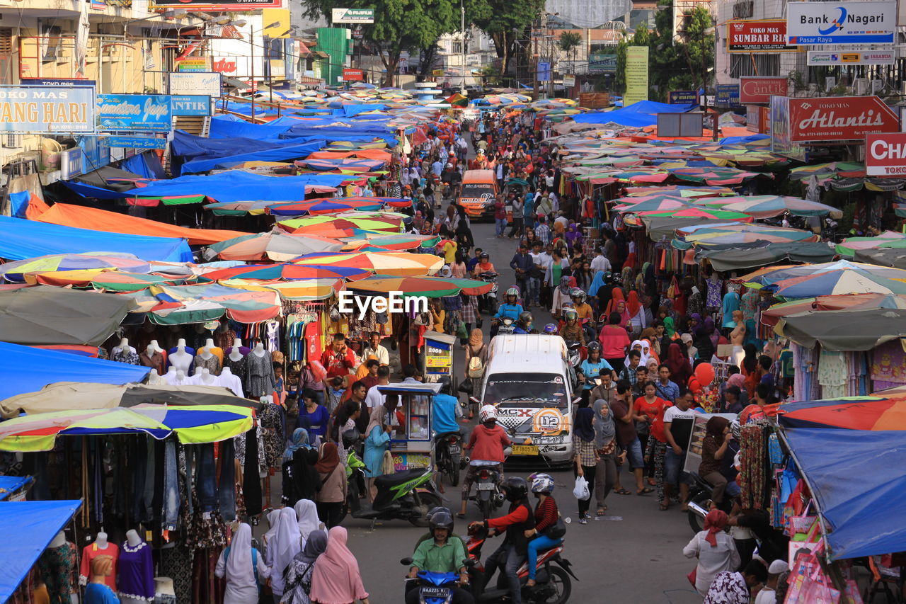 HIGH ANGLE VIEW OF PEOPLE AT MARKET STALL