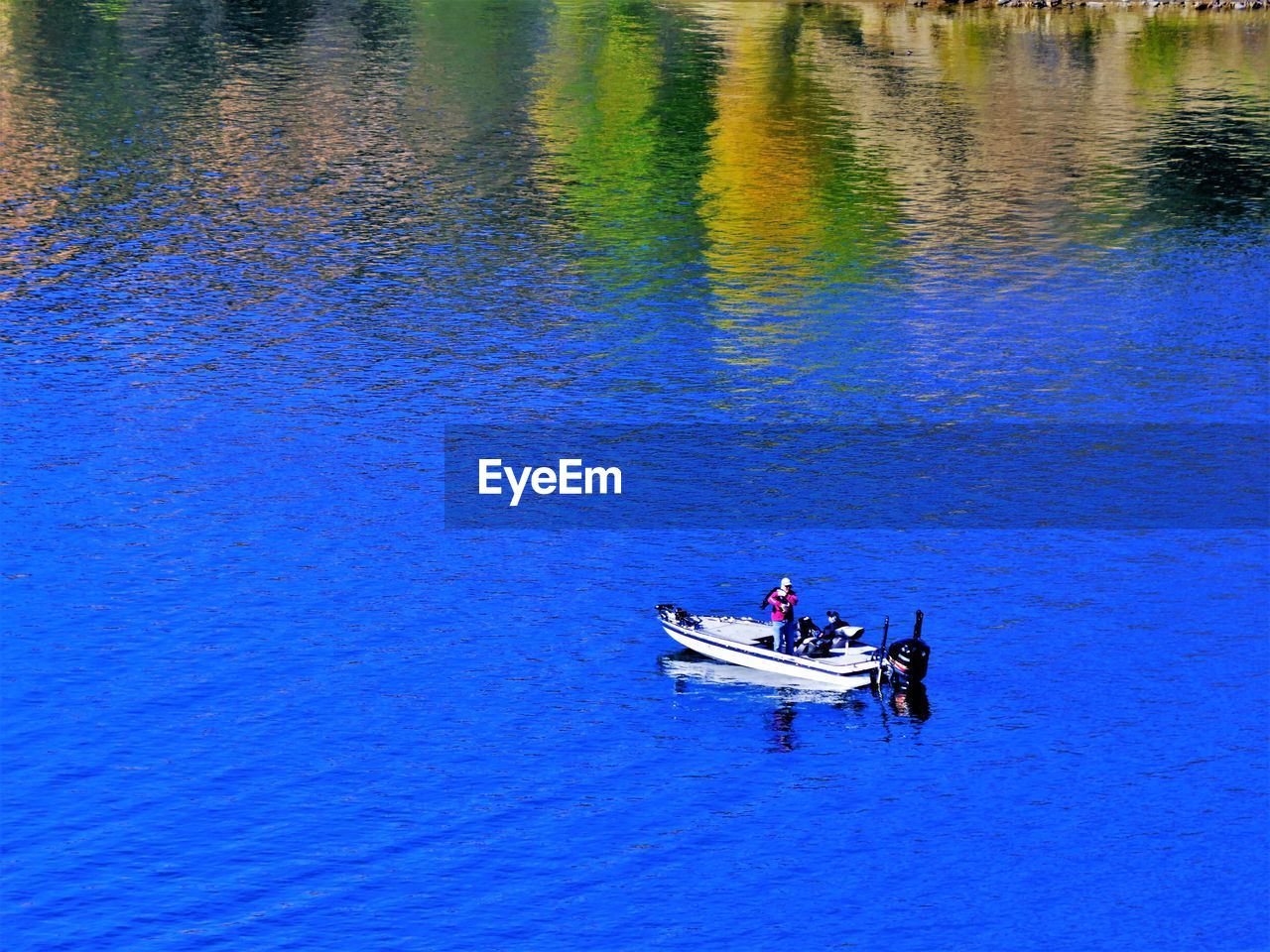 HIGH ANGLE VIEW OF MEN ON BOAT IN SEA