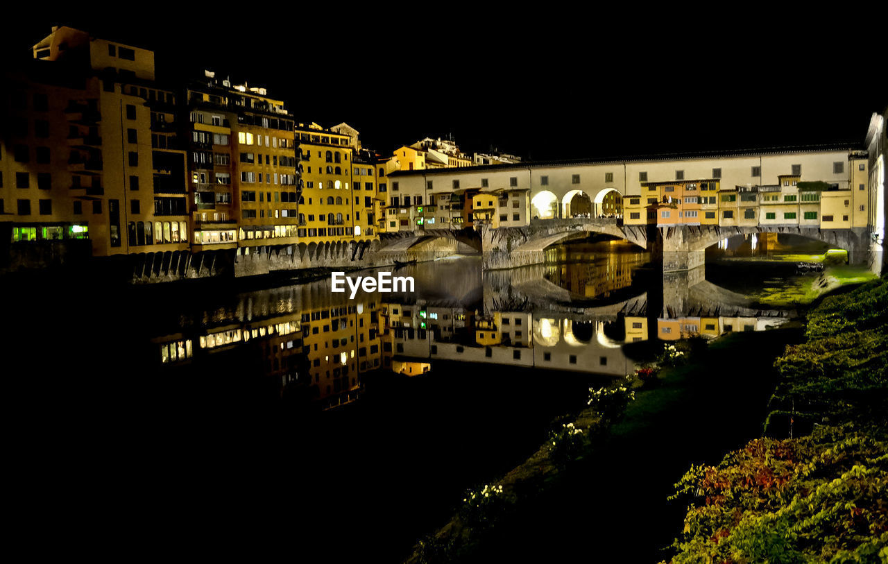 Reflection of ponte vecchio in river at night