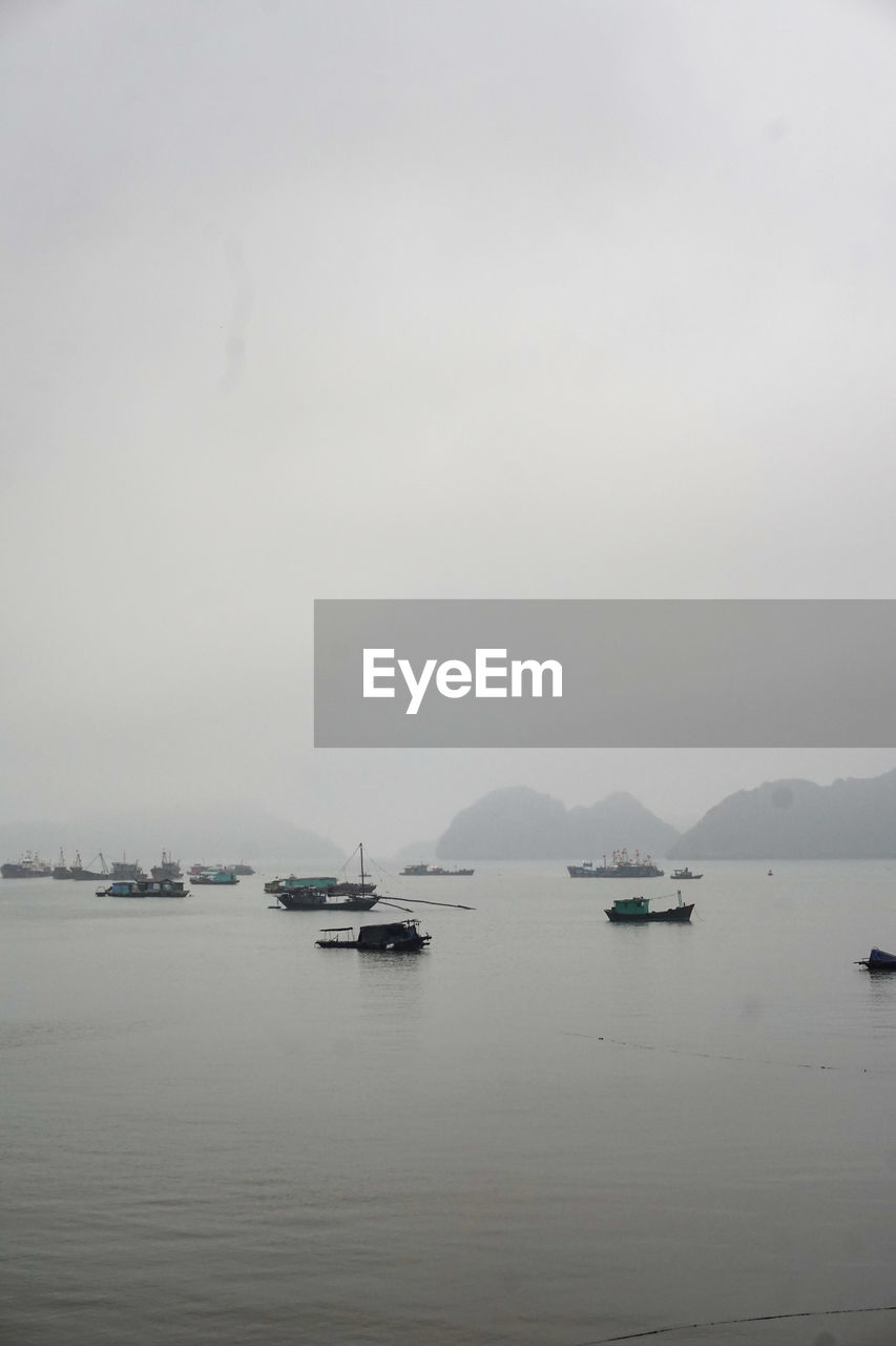 SAILBOATS IN SEA AGAINST SKY