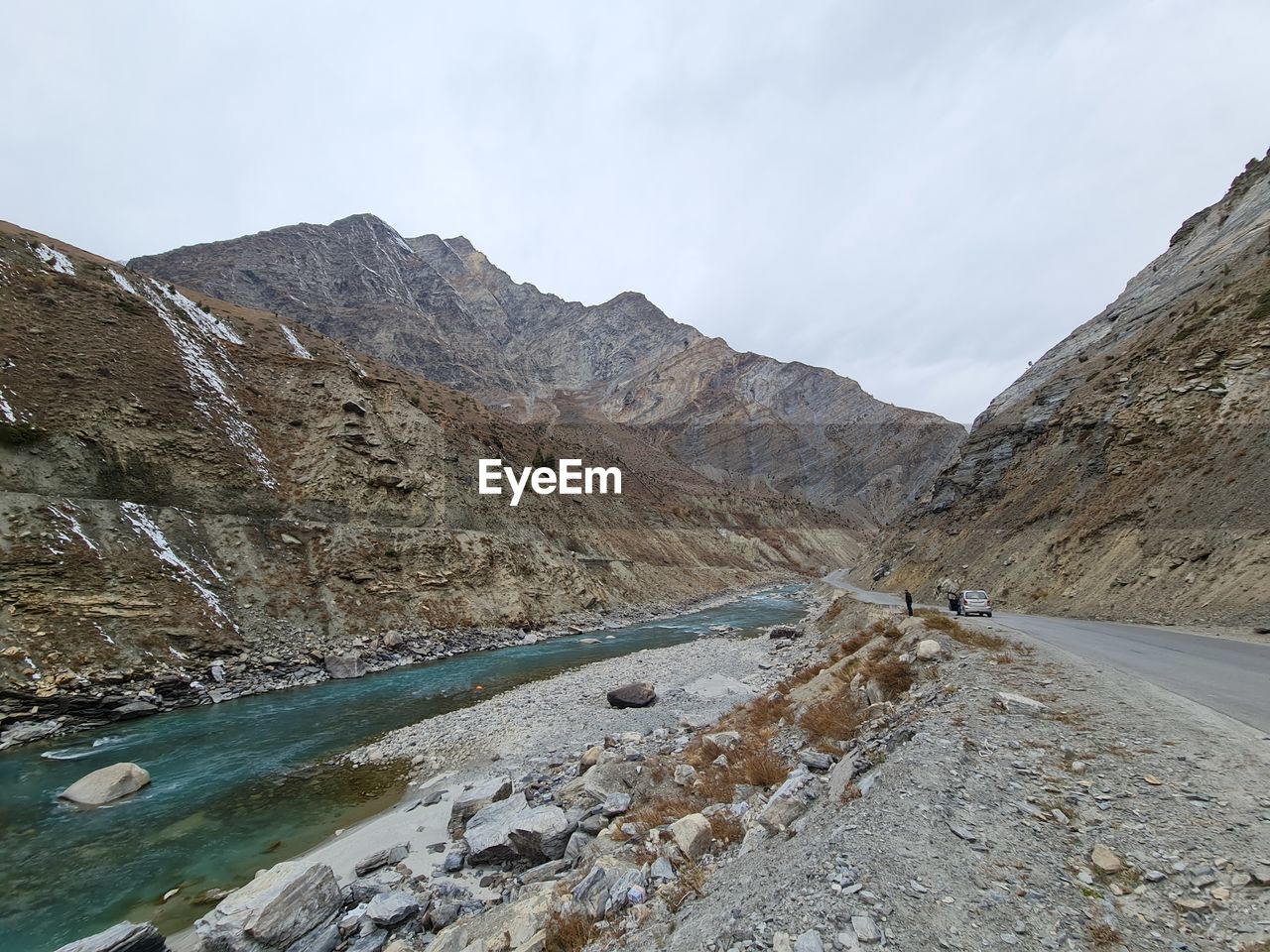 Scenic view of road by mountains against sky