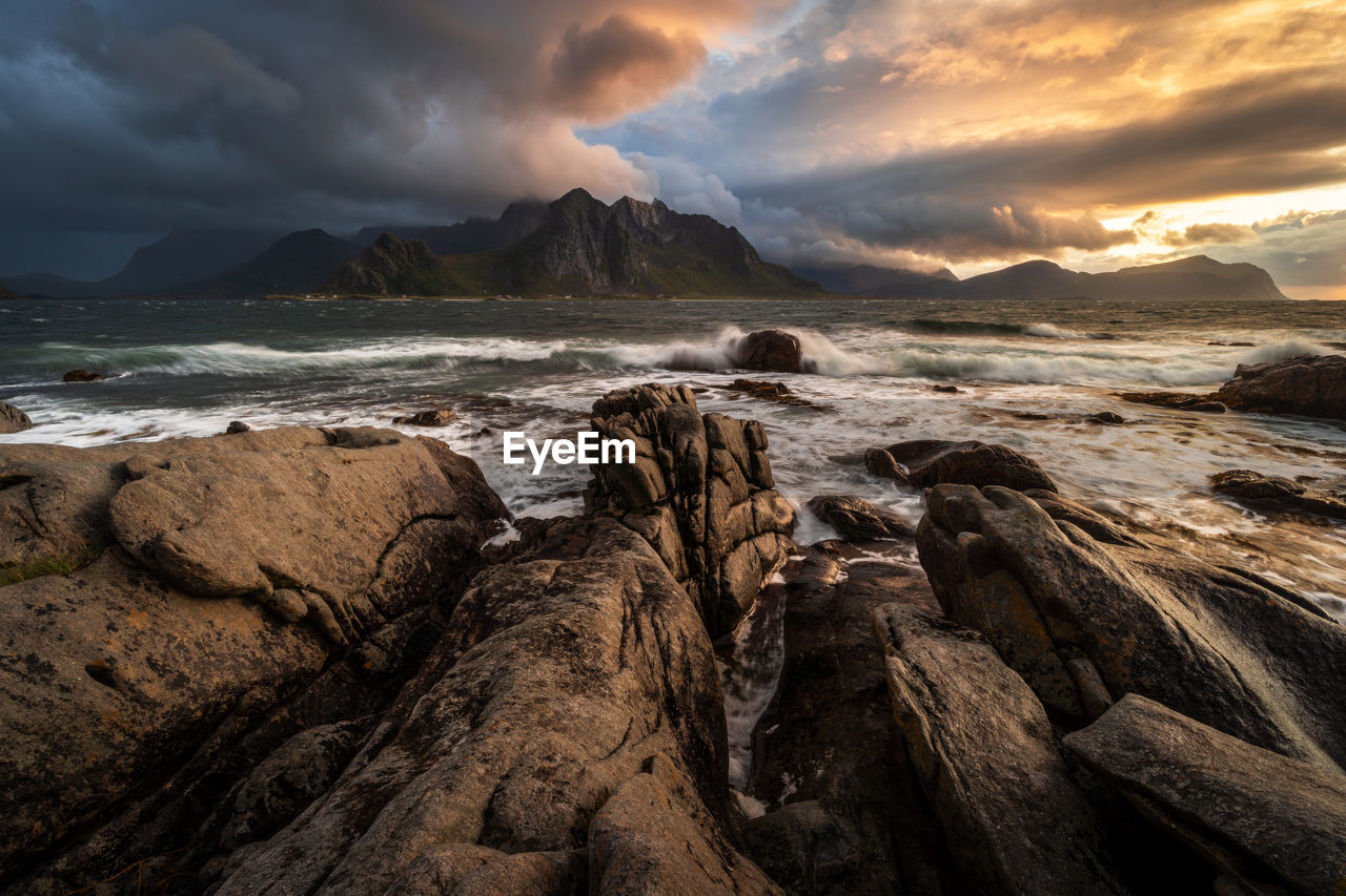 scenic view of sea against cloudy sky during sunset