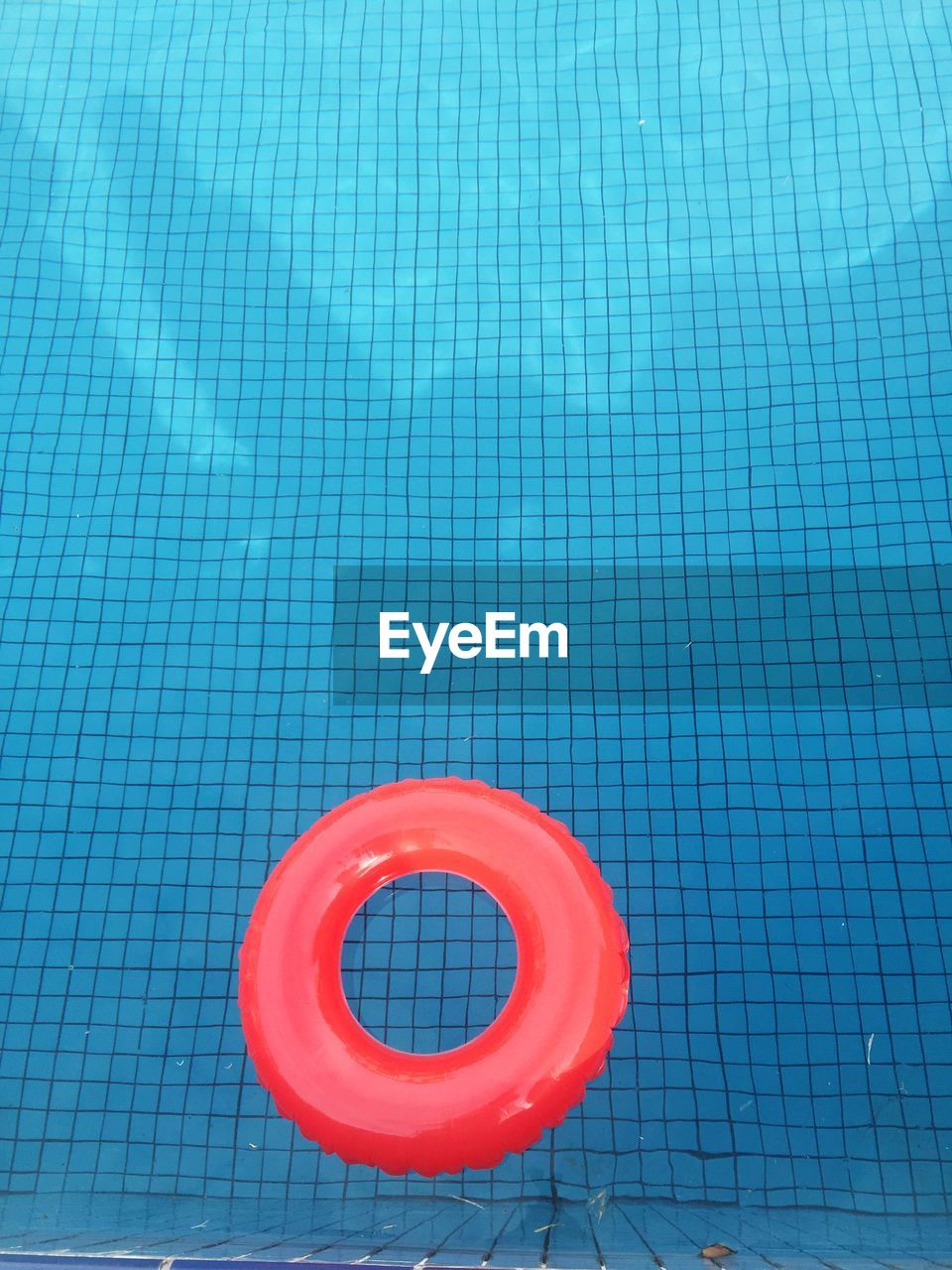 High angle view of red inflatable ring floating on swimming pool