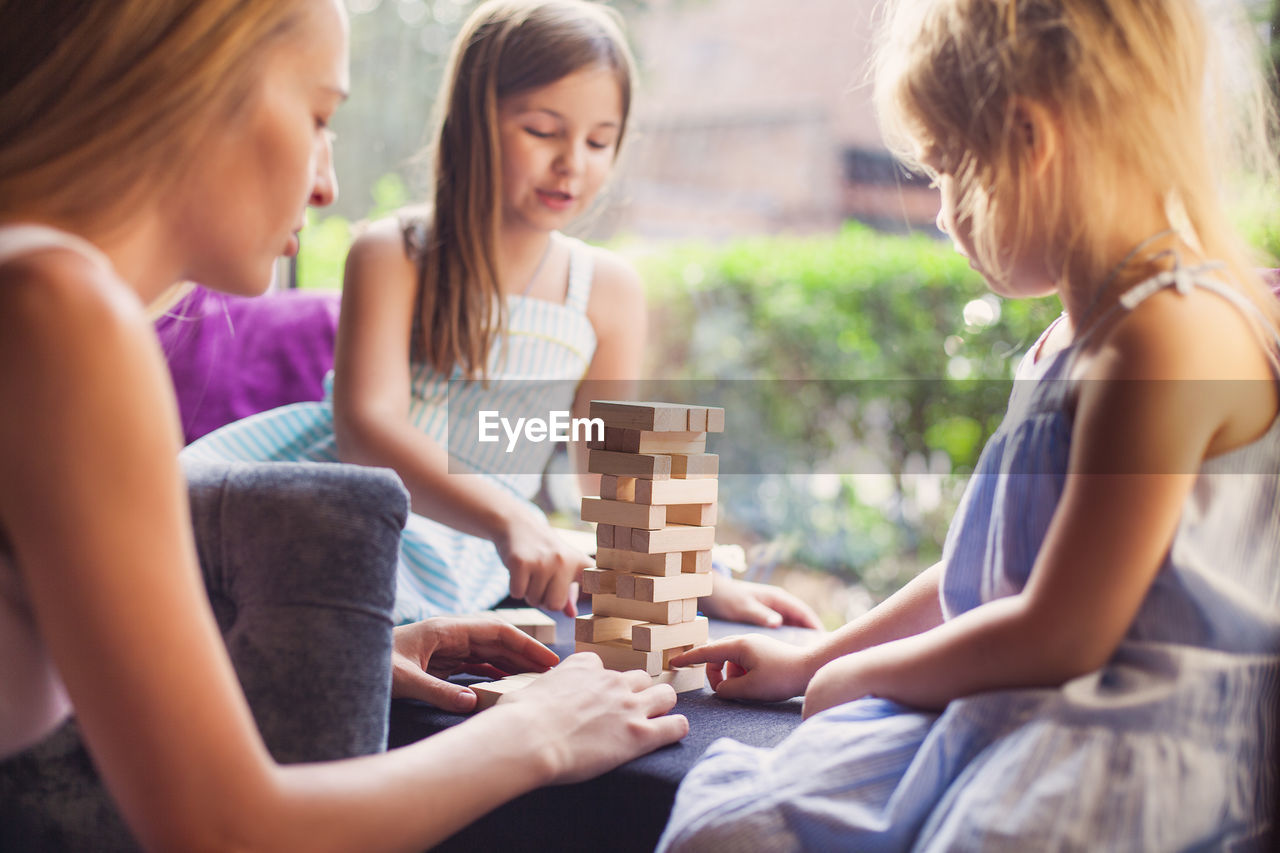 Girls playing with wooden blocks at home