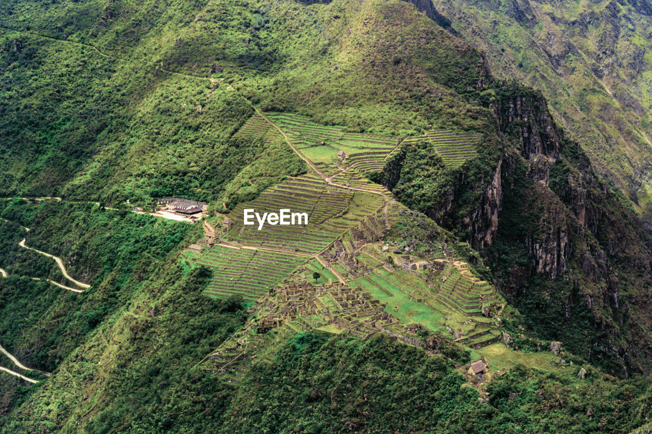 Cliffs with agricultural terraces and old houses in the ancient inca city of machu picchu, in peru.