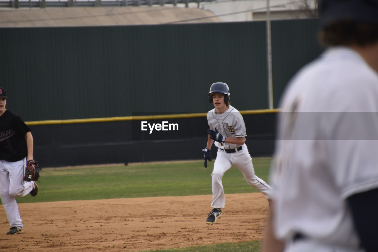 Teen boy running bases at baseball game 