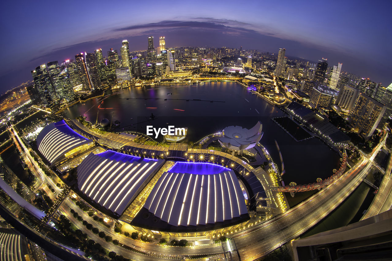 HIGH ANGLE VIEW OF ILLUMINATED BUILDINGS AGAINST SKY AT NIGHT