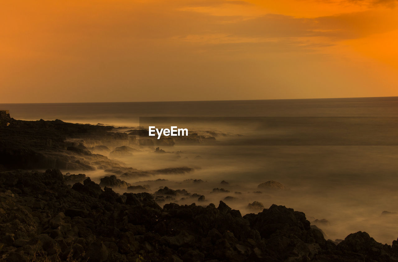 SCENIC VIEW OF SEA AGAINST SKY AT SUNSET