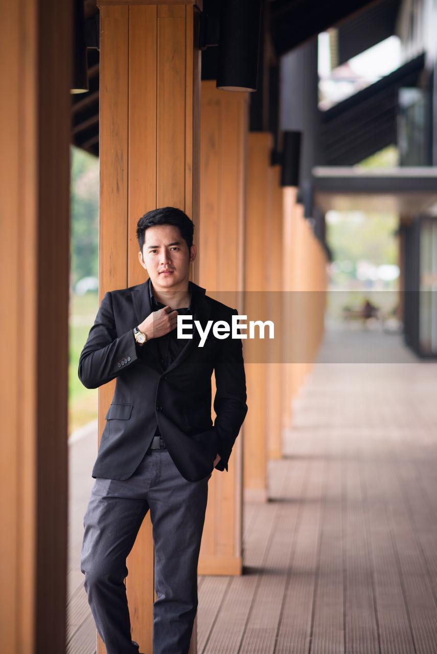 Portrait of confident young man standing in corridor