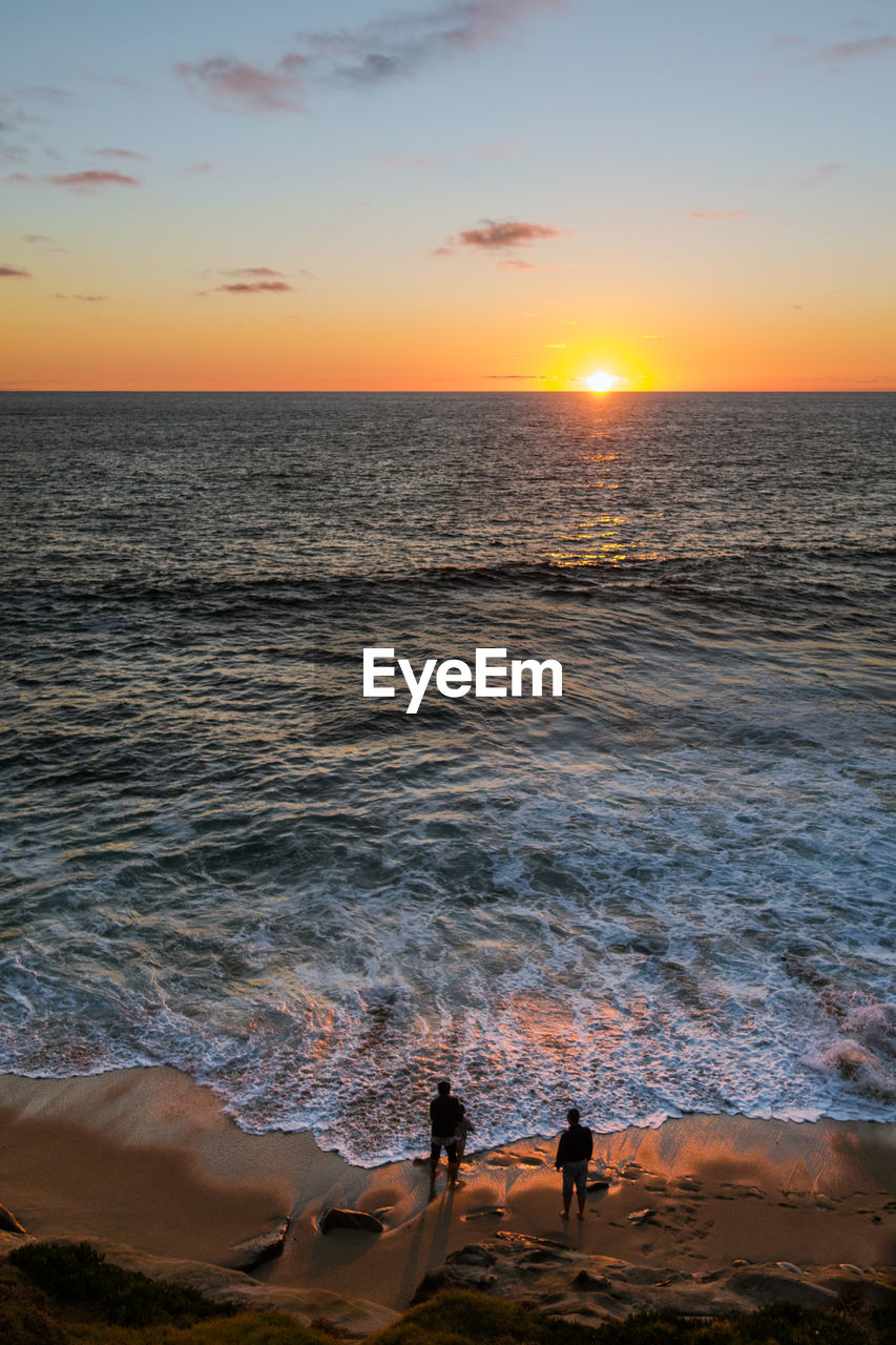 High angle view of people at beach during sunset