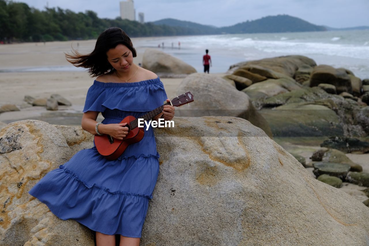 YOUNG WOMAN PLAYING IN SEA