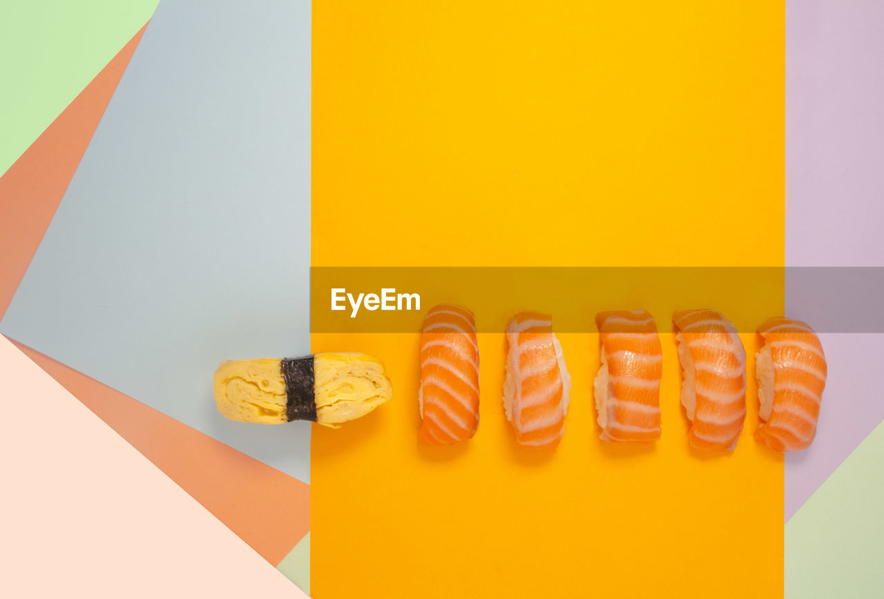 DIRECTLY ABOVE SHOT OF MULTI COLORED CANDIES ON YELLOW BACKGROUND