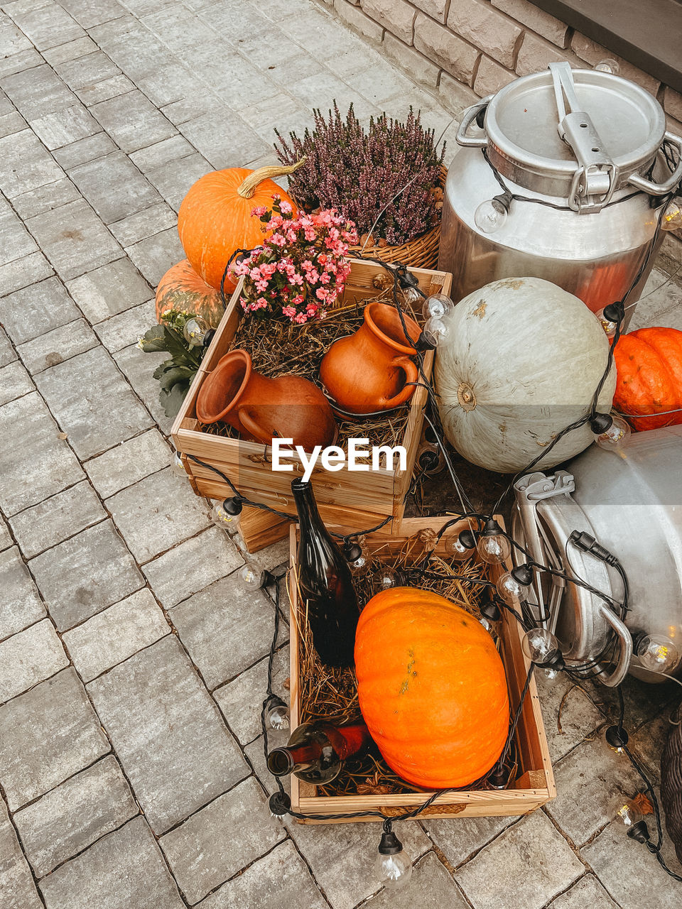 Pumpkin, clay jugs lie with straw in wooden boxes, next to iron cans, and a basket of lavender
