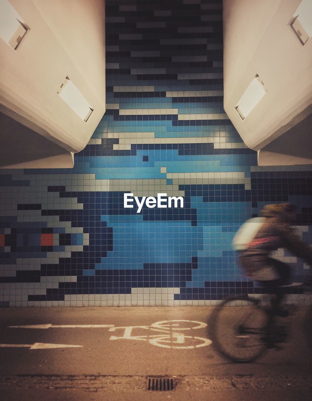 Blurred motion of person riding bicycle on subway