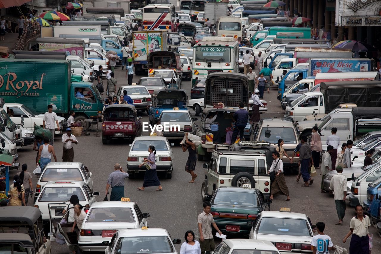 High angle view of people and vehicles on street in city