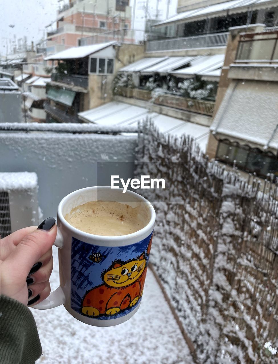hand, cup, snow, mug, one person, drink, food and drink, coffee, cold temperature, holding, architecture, winter, coffee cup, city, hot drink, refreshment, building exterior, built structure, adult, lifestyles, frozen, day, personal perspective, food, building, tea, outdoors, leisure activity, nature, freshness, street, women