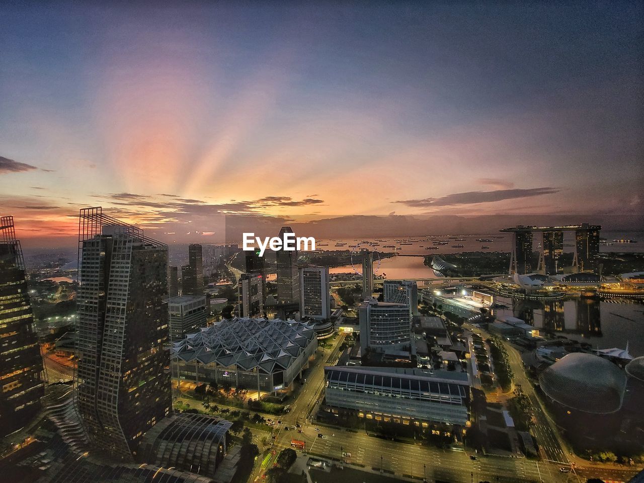 High angle view of illuminated cityscape against sky during sunset