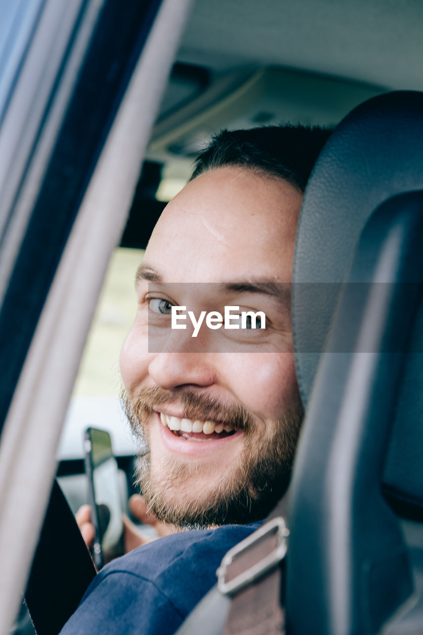 Portrait of smiling man in car