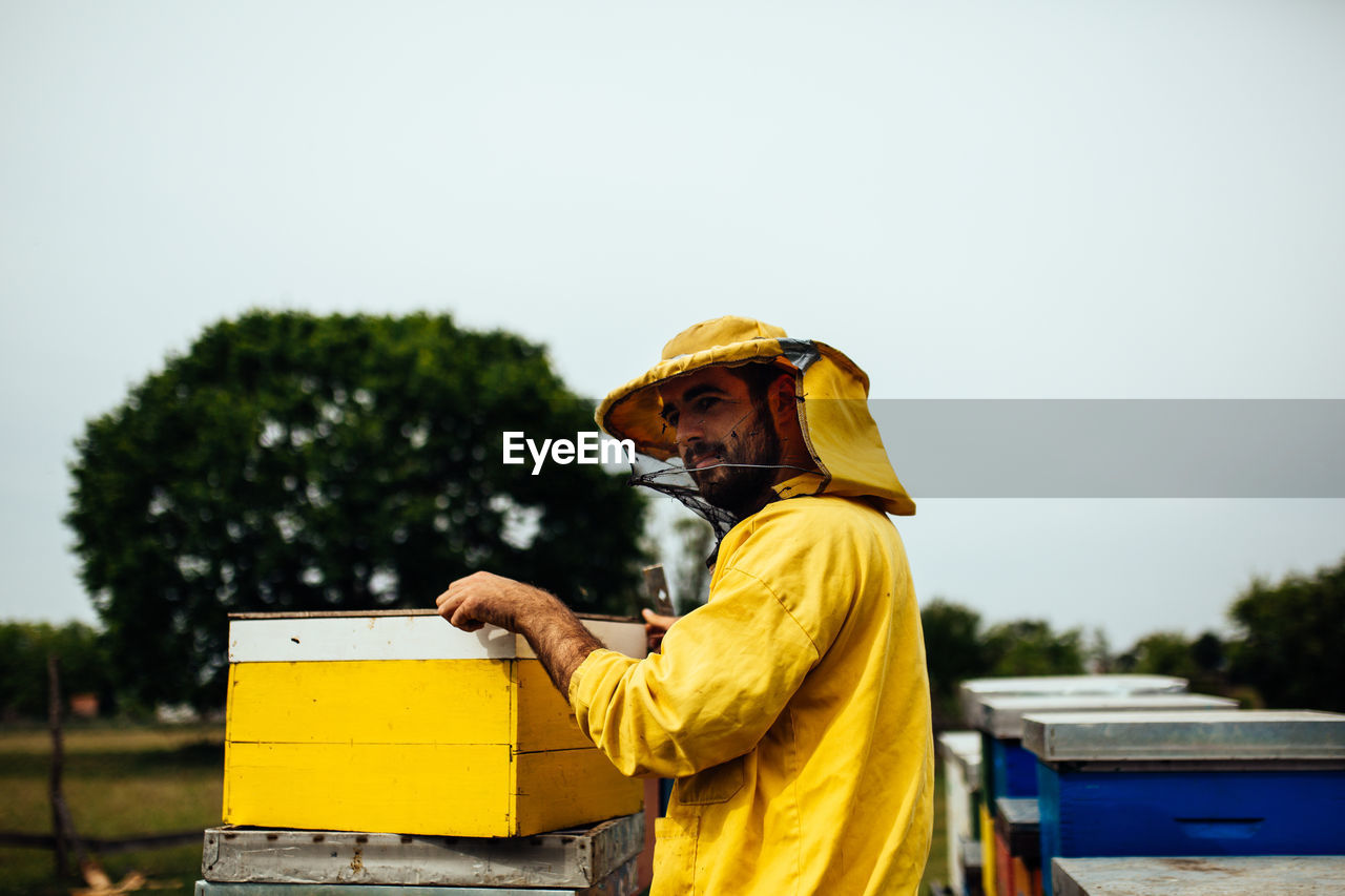 Beekeeper working over beehive at farm