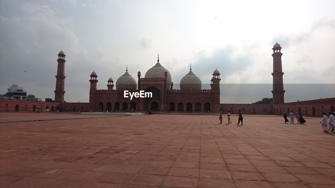 GROUP OF PEOPLE IN TEMPLE AGAINST BUILDING