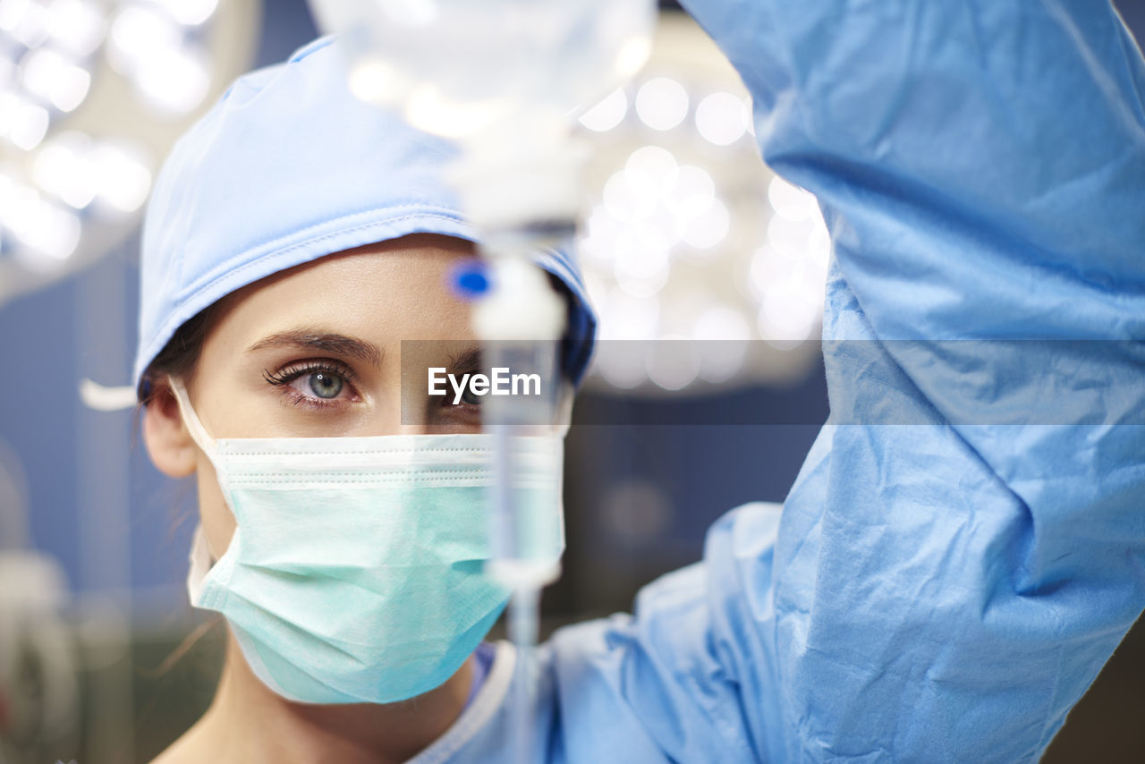 Female doctor looking iv drip in emergency room