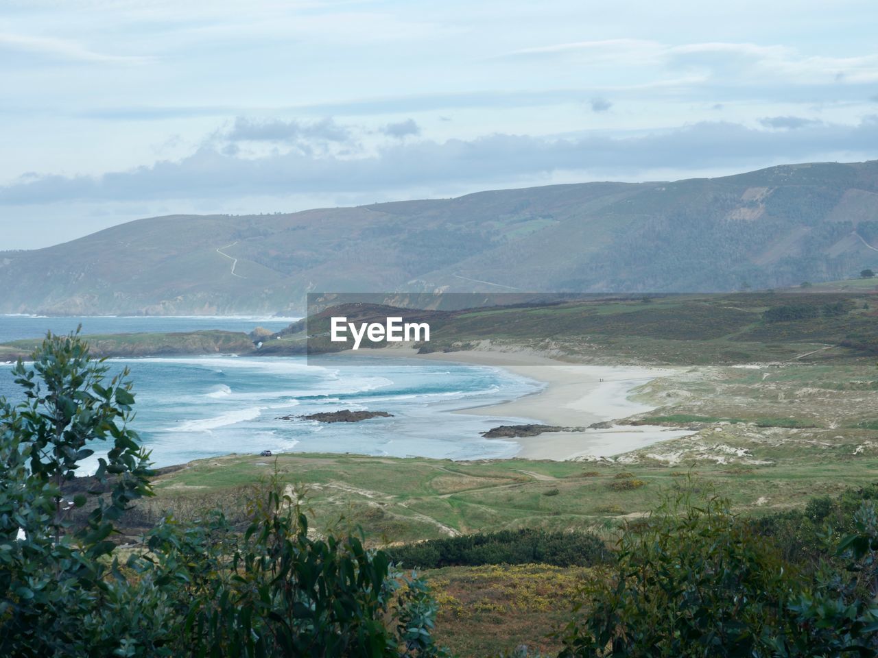 Scenic view of sea and mountains against sky