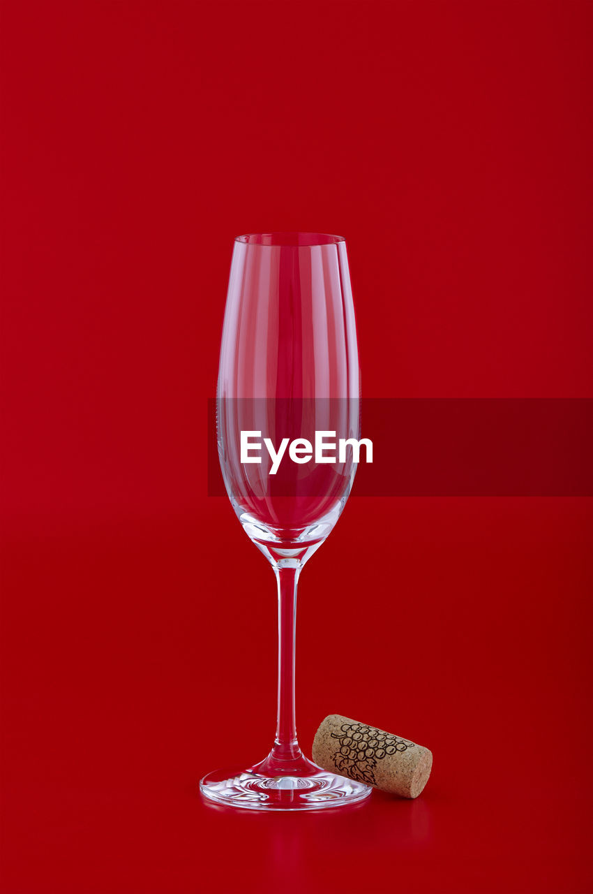 Close-up of empty wineglass against red background