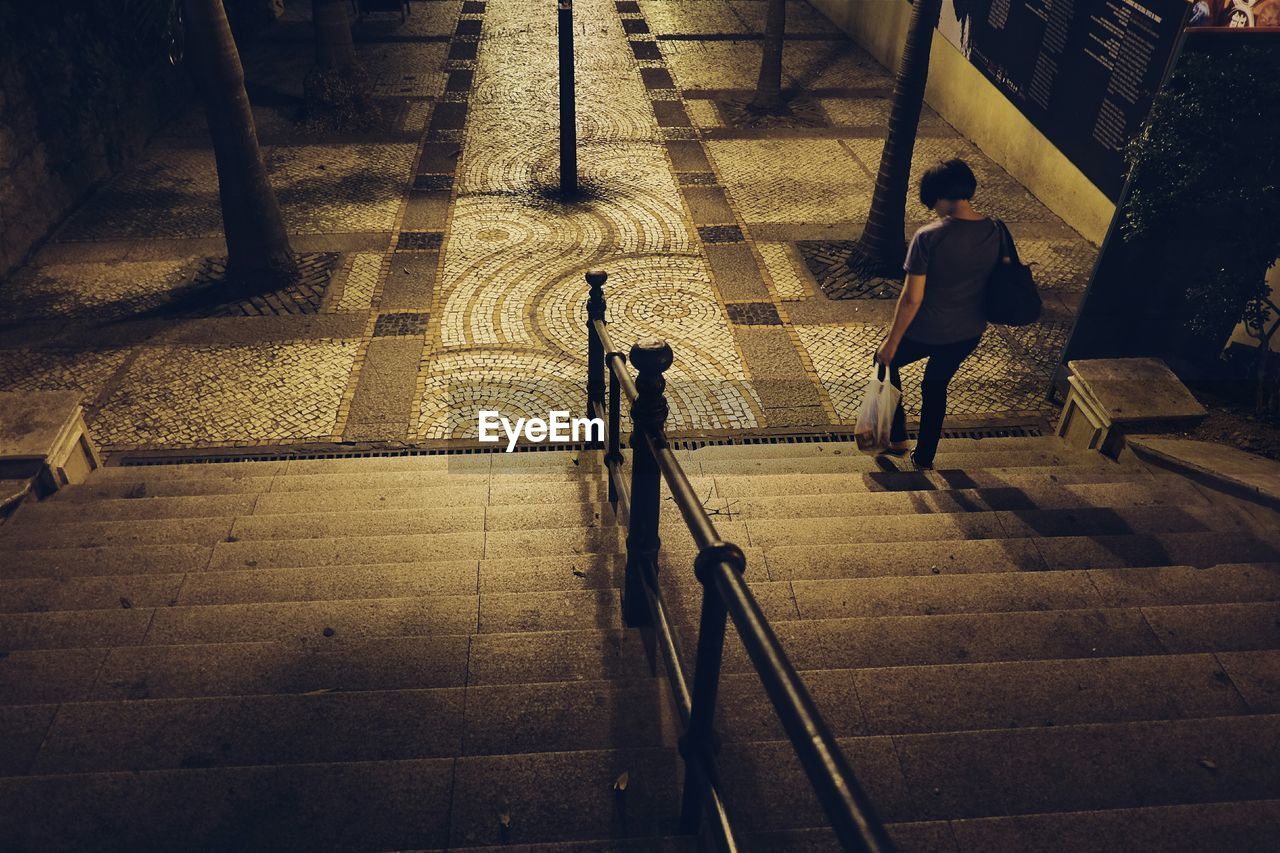 High angle view of woman walking on staircase