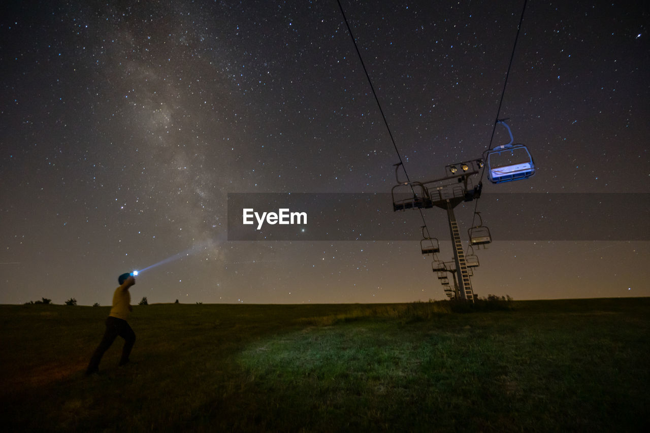 Man on field against sky at night