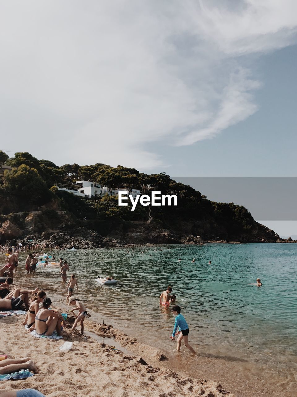 People enjoying at beach against sky