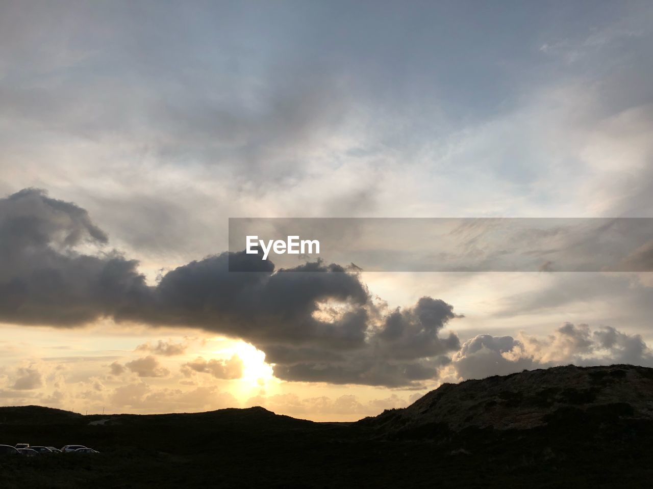 LOW ANGLE VIEW OF SILHOUETTE MOUNTAIN AGAINST DRAMATIC SKY