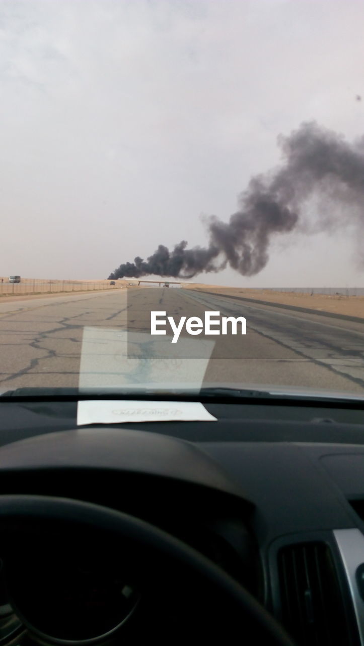 CLOSE-UP OF CAR WINDSHIELD ON ROAD