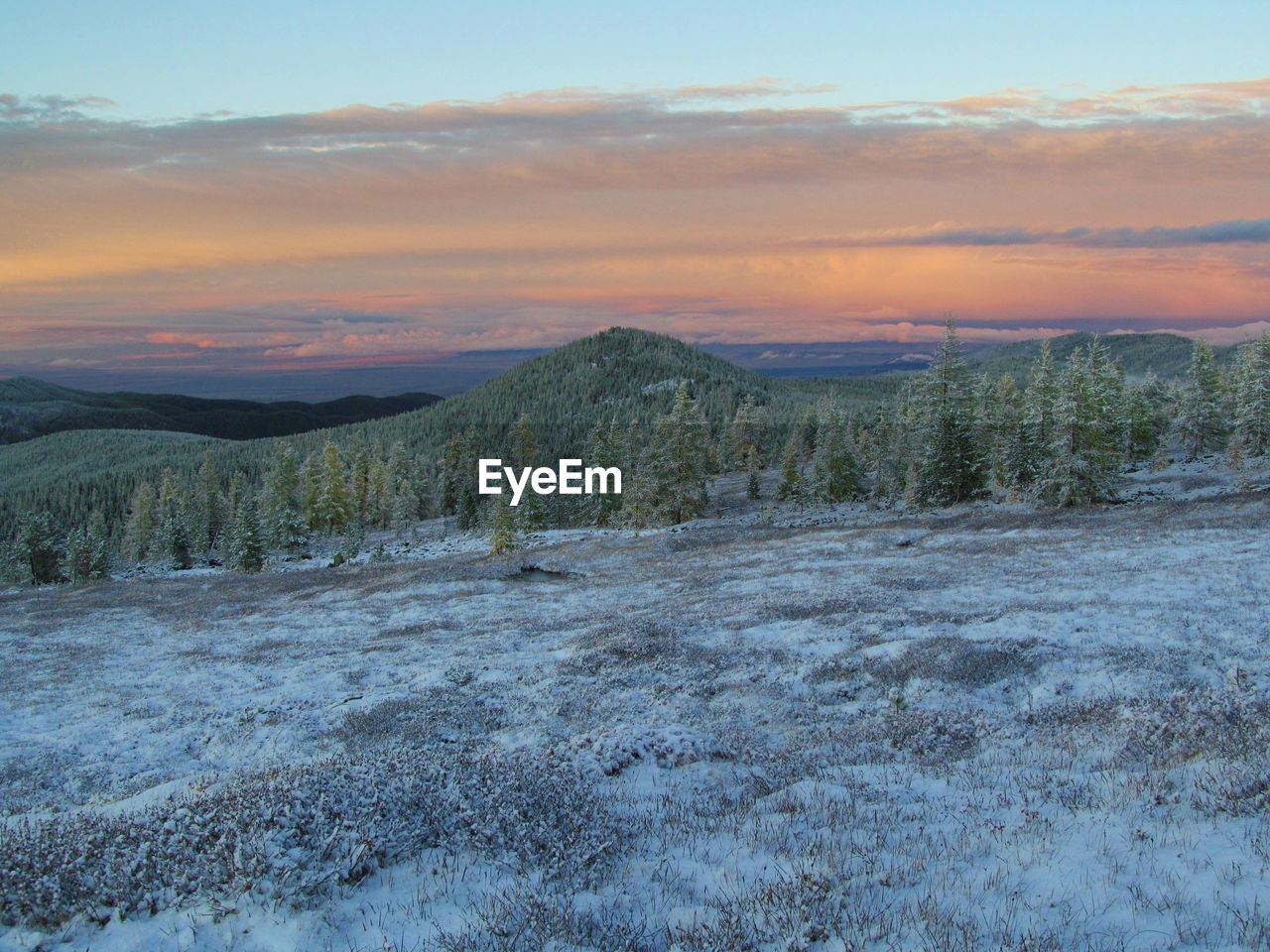 SCENIC VIEW OF SNOW COVERED LAND AGAINST SKY DURING SUNSET