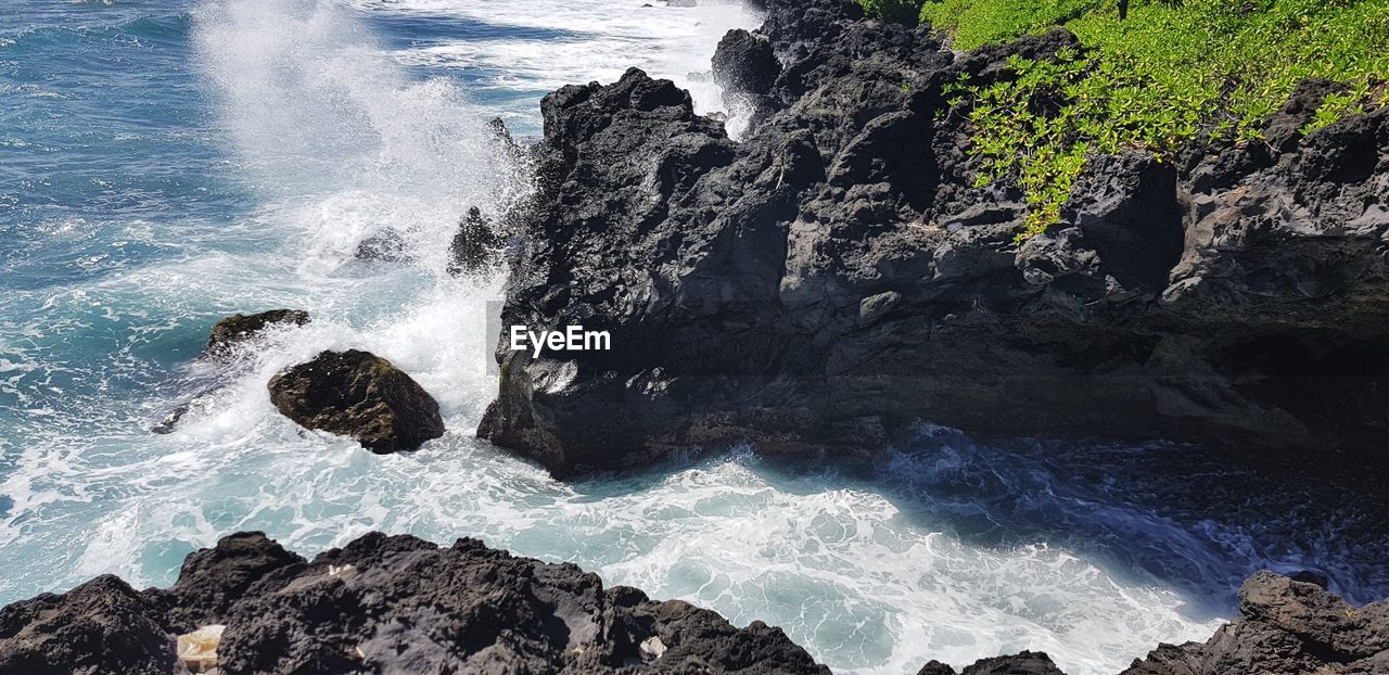 WAVES SPLASHING ON ROCKS AT BEACH