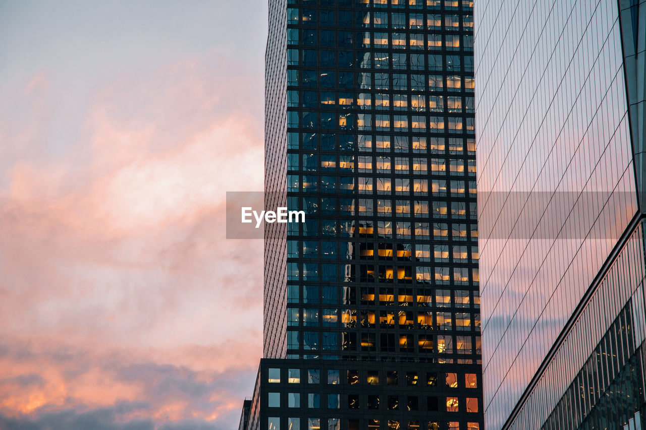 Low angle view of modern buildings against sky during sunset