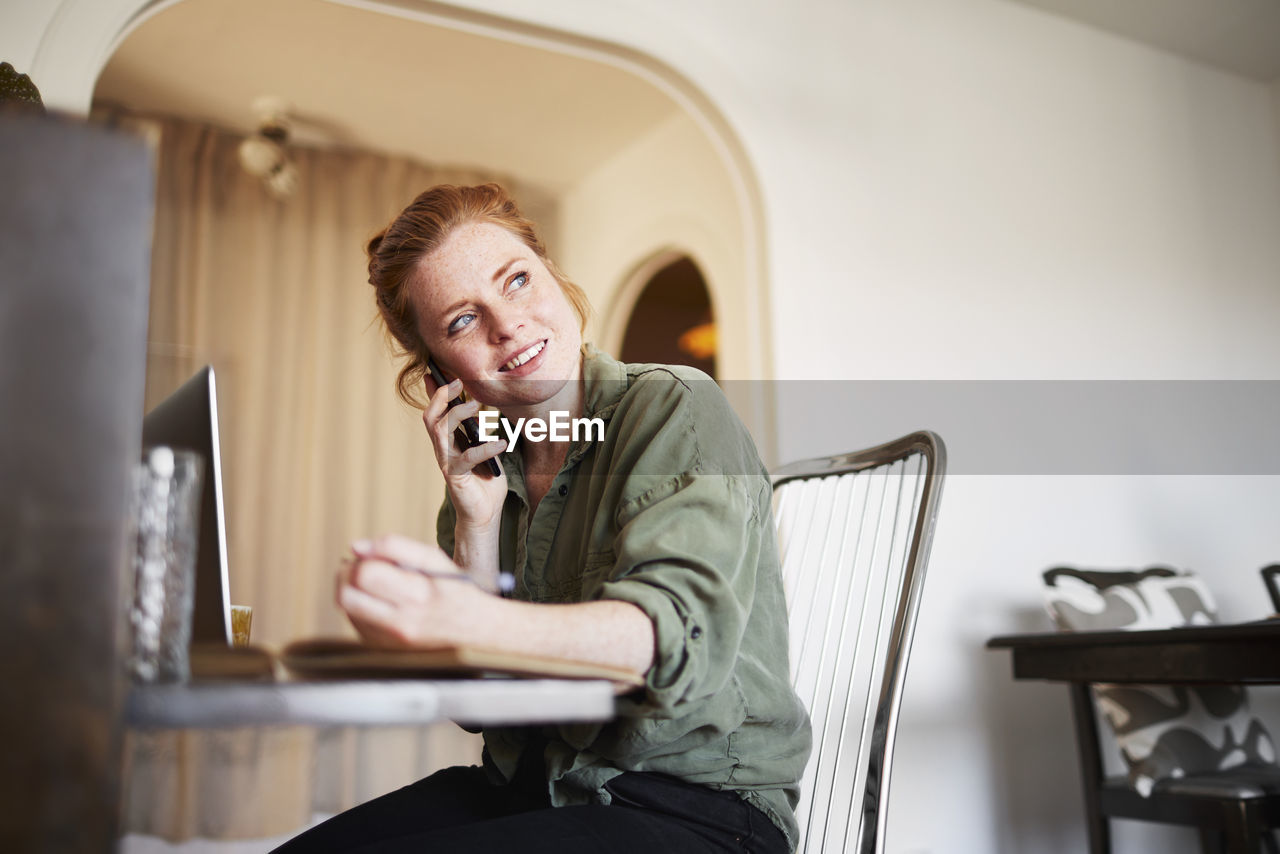 Woman at home talking via cell phone