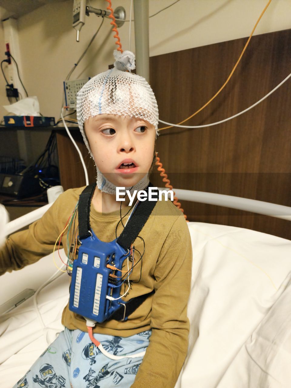 High angle view of cute young  boy sitting on the hospital bed, sleep test, technology, hospital