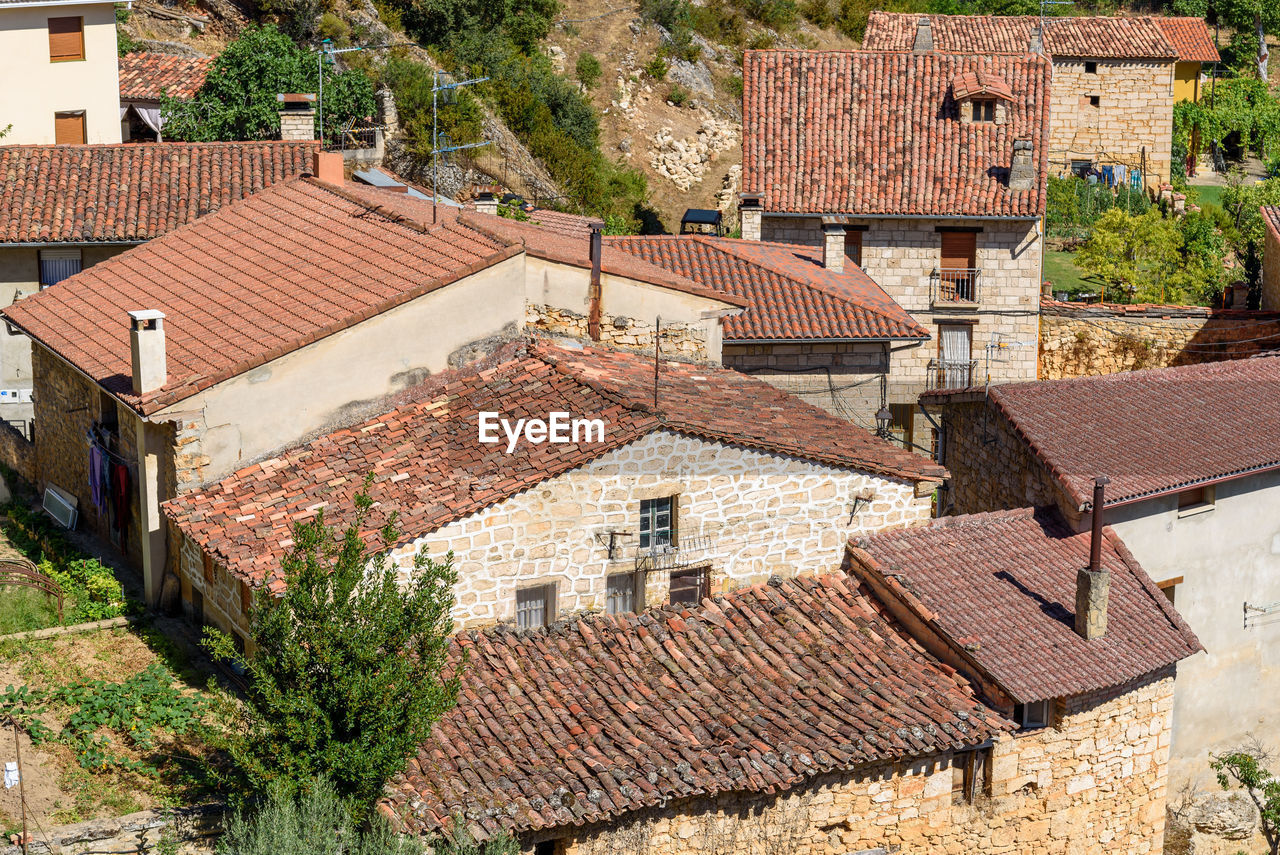 Background of old village houses with stone walls and red tile roofs.