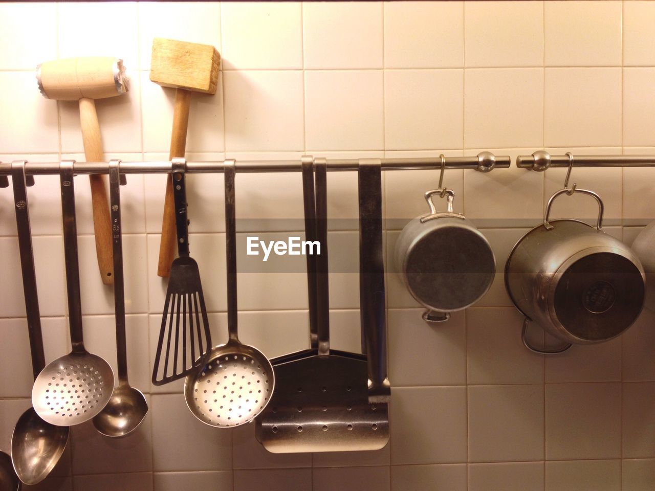 Cooking utensils hanging on pole mounted to wall