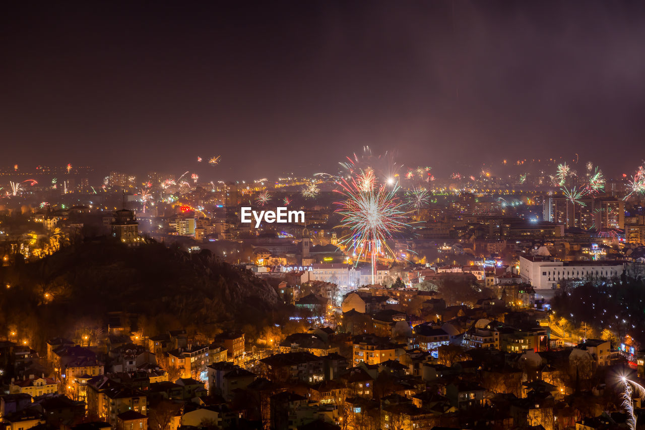 Illuminated cityscape against sky at night