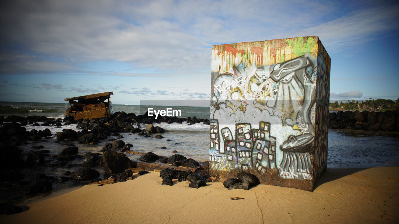 GRAFFITI ON SHORE AGAINST SKY