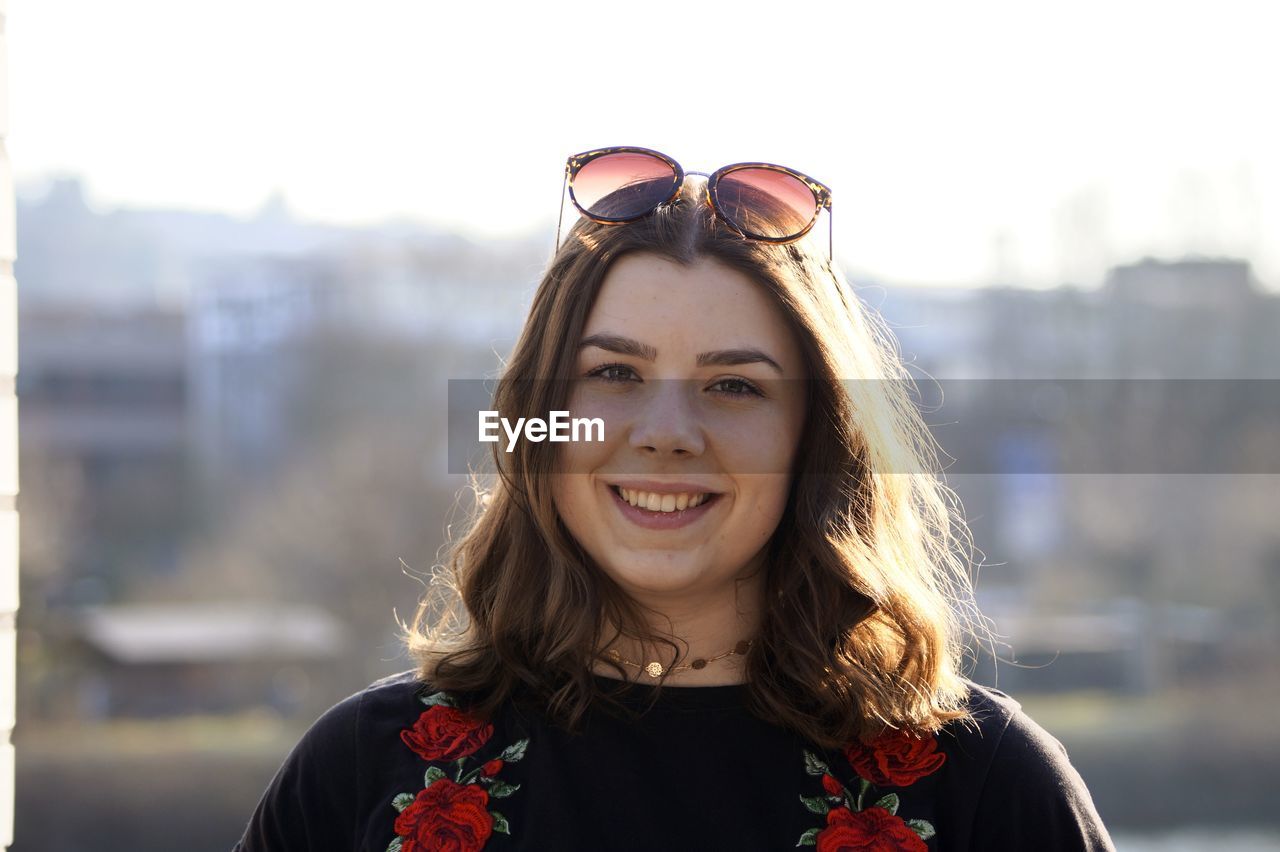 Close-up portrait of woman smiling while standing in city