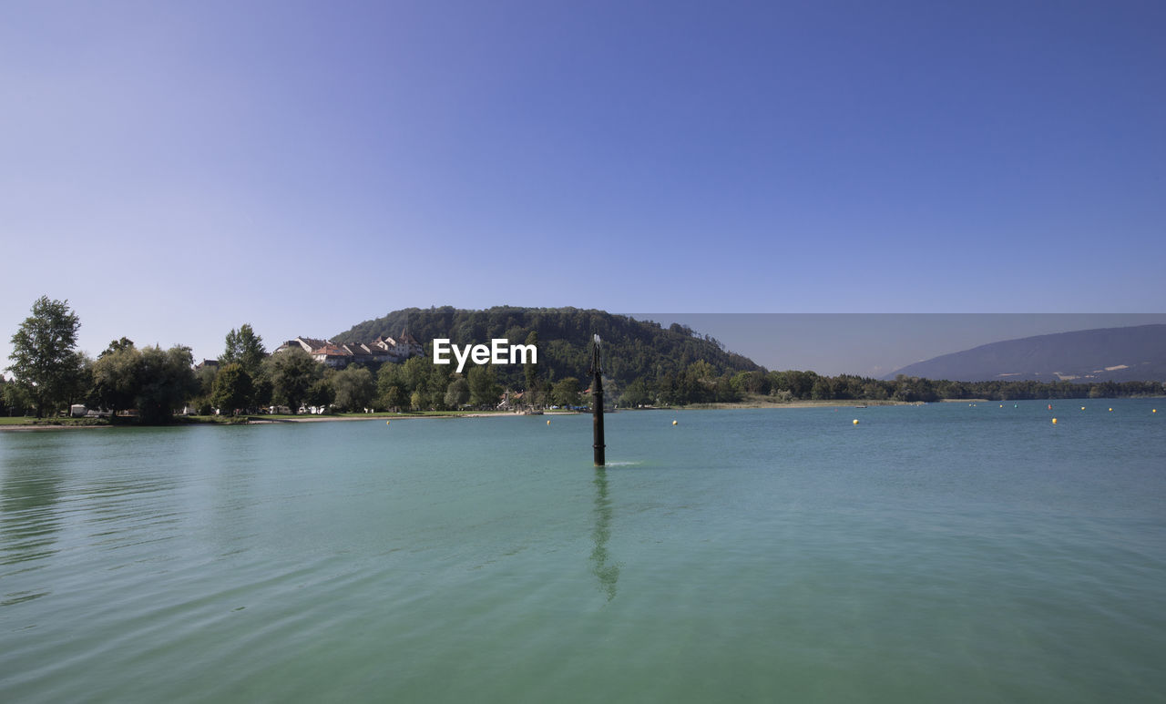 Scenic view of lake against clear blue sky