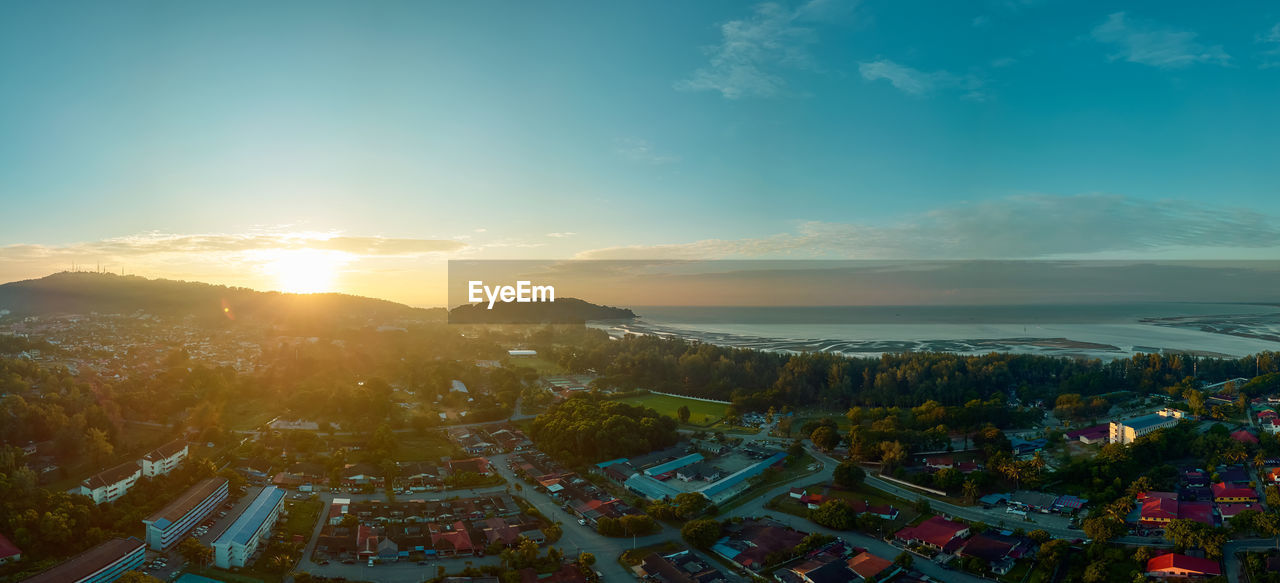 HIGH ANGLE SHOT OF TOWNSCAPE AGAINST SKY DURING SUNSET