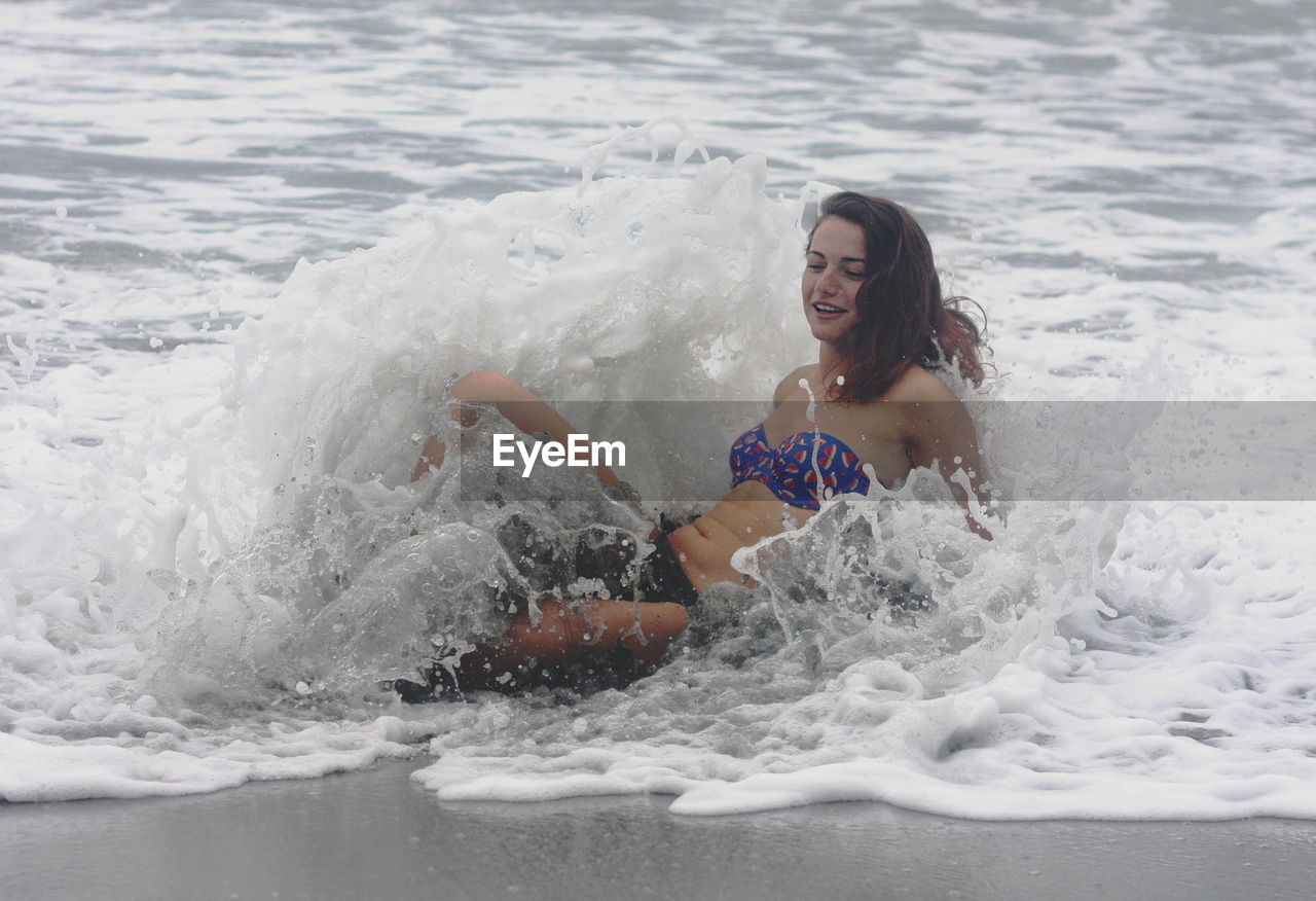 YOUNG WOMAN IN SWIMMING POOL AT SEA